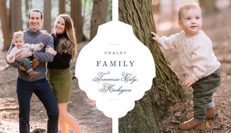 A family of three stands in a forest while lit by sunshine for Traverse City fall family photography