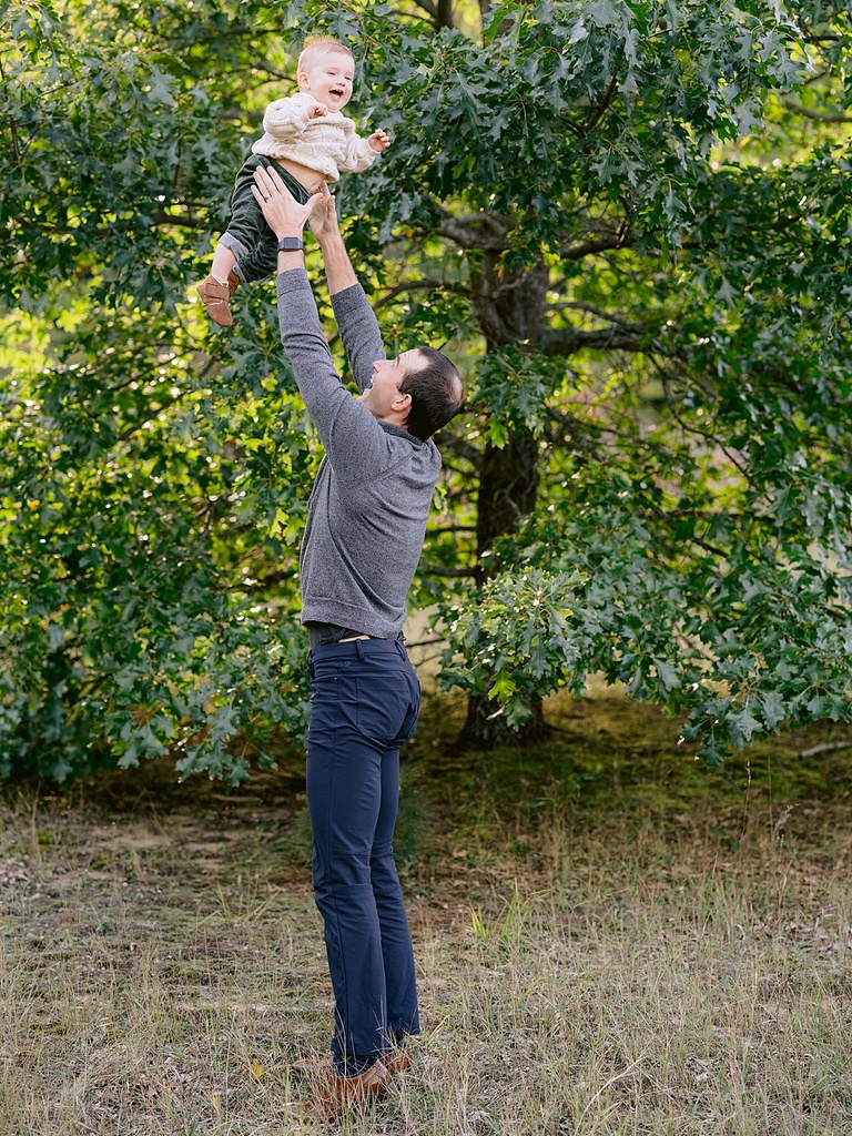 A father tossing his son into the air and catching him while his son is laughing