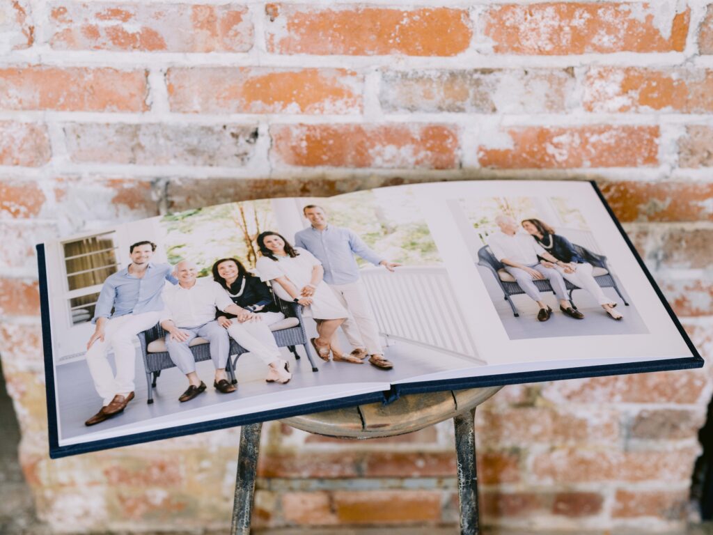 Open 12x12 navy blue linen family portrait album displaying professionally printed Northern Michigan family photos across full spread pages.