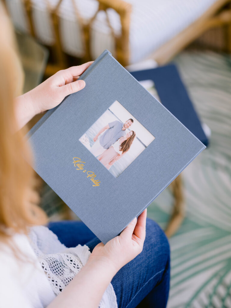 Light blue 10x10 linen couple’s portrait album with gold debossing being held and featuring timeless Northern Michigan photography.